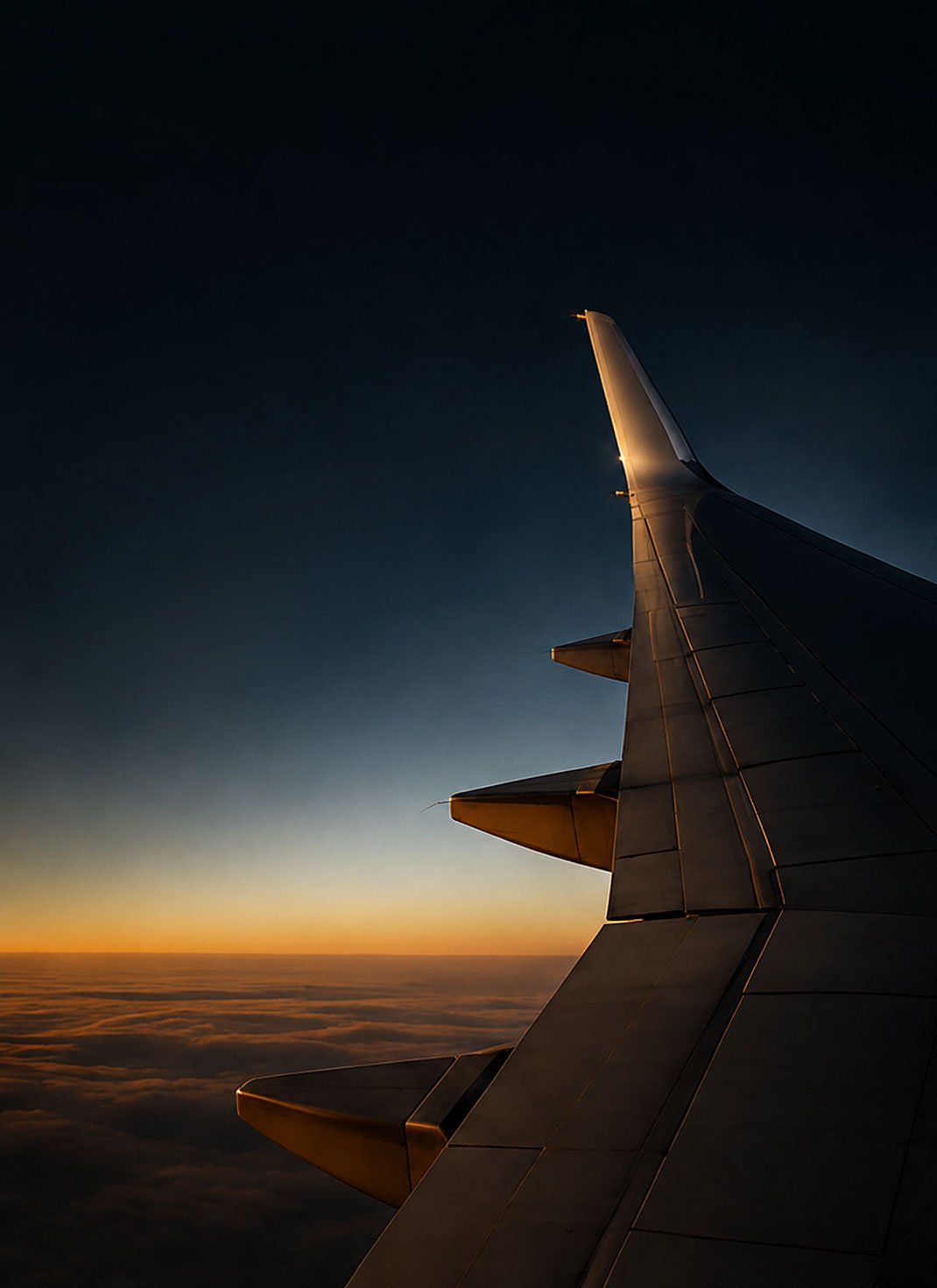 Aircraft wing above the clouds at sunset